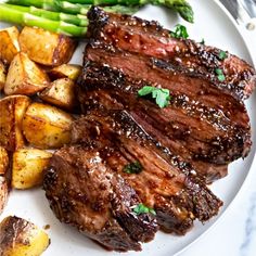 steak, potatoes and asparagus on a white plate