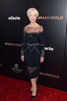 an older woman in a black dress on the red carpet with her legs spread out