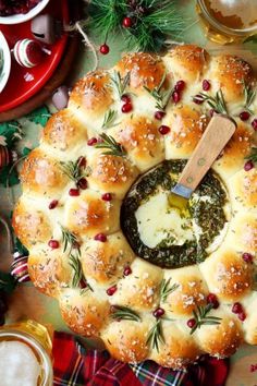 a platter filled with rolls covered in cheese and herbs, surrounded by other holiday foods