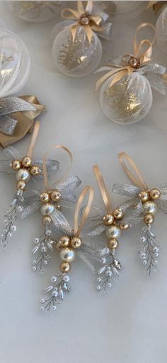 gold and silver ornaments are arranged on a white tablecloth with bows, ribbons, and baubles