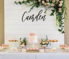 a table topped with cakes and cupcakes next to a sign that says candlen