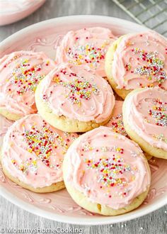 pink frosted cookies with sprinkles on a plate