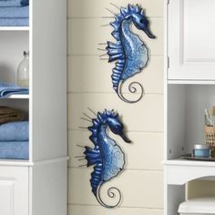 two blue seahorses on the side of a white bookcase