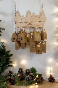 christmas decorations hanging on the wall in front of a tree