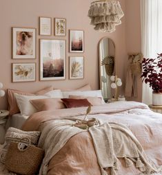 a bedroom with pink walls and pictures on the wall above the bed, along with a wicker basket