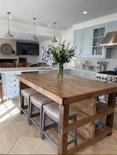 a kitchen island with stools in front of it and a vase on the counter