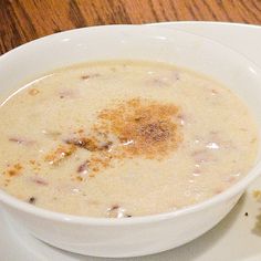 a white bowl filled with soup on top of a plate