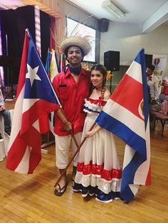 a man and woman standing next to each other holding flags