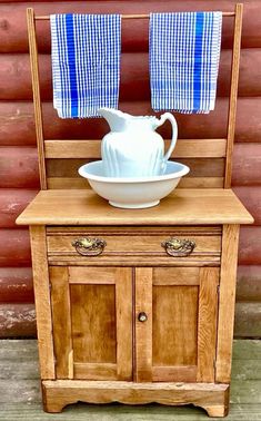 a wooden chair with a white bowl on it and two blue towels hanging from the back