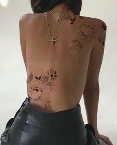 the back of a woman's body with tattoos on her upper and lower half