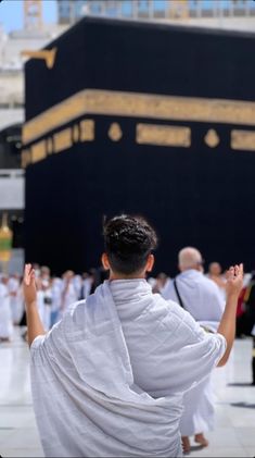 a group of people standing in front of the ka'bah with their hands up