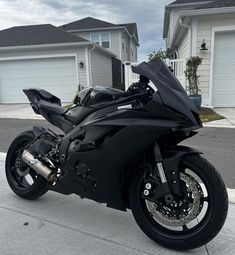 a black motorcycle parked in front of a house