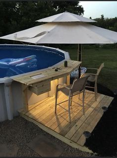 an above ground swimming pool with umbrellas and chairs on the deck next to it