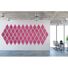 an office with a large pink diamond wall decal on the wall and chairs in front of it