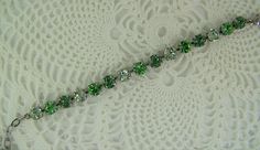 "Shades of green are displayed in this sparkling Swarovski cup chain bracelet. Each carefully hand set 8mm (39ss) crystal is held with four prongs in an antique silver ox 15 cup bracelet, closed with a lobster claw clasp. The peridot, erinite and chrysolite crystals blend in lovely shades of green bracelet. These chatons are set in this nickle free metal, silver toned bracelet. A 2 1/2\" extender chain finished with an peridot Swarovski bead making this bracelet adjust from 6 1/2\" to 8 3/4\", f Green Crystal Bracelet With Rhinestones, Green Crystal Bracelets With Sparkling Stones, Green Crystal Round Bracelets, Green Crystal Bracelet For Weddings, Green Crystal Wedding Bracelet, Green Rhinestone Bracelets For Wedding, Cup Chain Bracelet, Violet Necklace, Bracelet Emerald