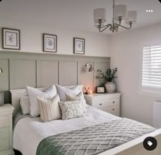 a bedroom with a bed, nightstands and pictures on the wall