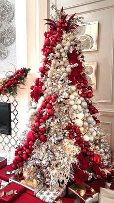 a red and white christmas tree with ornaments on the top is surrounded by other holiday decorations