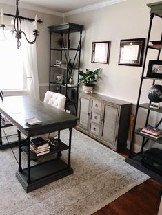 a living room with a table, chairs and bookshelves on the wall next to a window