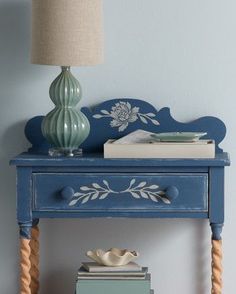 a blue table with books and a lamp on top