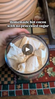 a person is holding a glass with some food in it and the caption reads homemade hot cocoa with no processed sugar