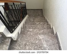 stairs leading up to the second floor in a house with white walls and black railings