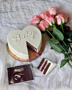 a piece of cake with the word baby written on it next to flowers and an album