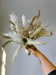 a person holding a bouquet of flowers in their hand