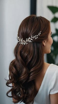 a woman wearing a bridal hair comb with leaves on the side and pearls in her hair