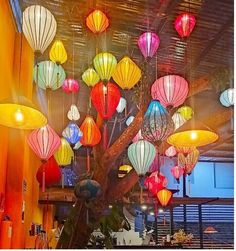 many colorful lanterns are hanging from the ceiling