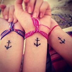 two girls with matching tattoos on their arms and one is holding the other's hand