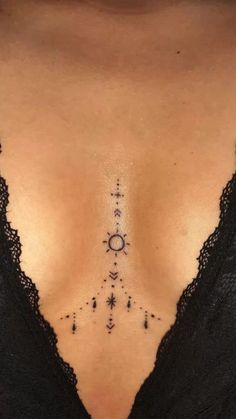 a woman's chest with an arrow and stars tattoo on her left side ribcage