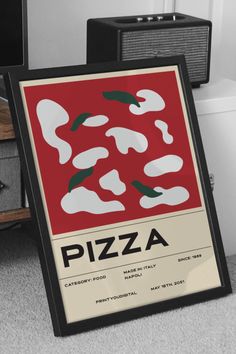 a pizza poster sitting on top of a floor next to a wall mounted speaker system