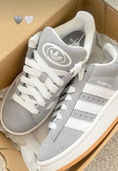 a pair of grey and white adidas sneakers in a box