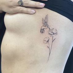 a woman's stomach with a humming tattoo on it