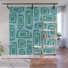 a green and blue wall mural in a living room with a ladder on the floor