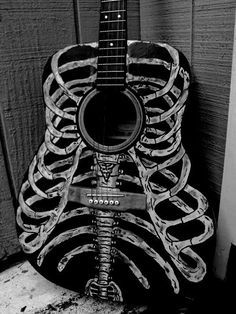 an acoustic guitar made out of skeleton bones is shown in this black and white photo