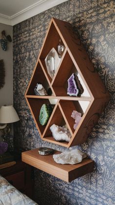 a shelving unit in the corner of a room with decorative wallpaper and blue walls