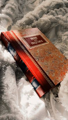 a red book sitting on top of a white blanket