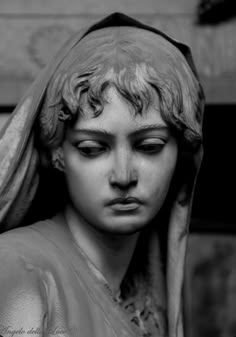 a black and white photo of a statue of a woman's head with her eyes closed