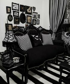 a black and white living room with lots of pictures on the wall above the couch