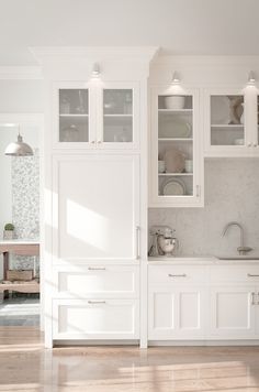 the kitchen is clean and ready to be used for cooking or baking, with all white cabinetry