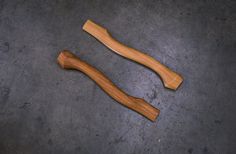 two wooden spoons sitting on top of a cement floor