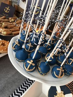 there are many blue and gold desserts on the table with white sticks in them