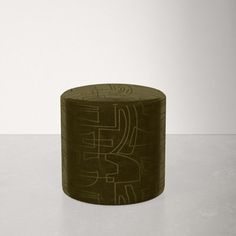 a round object with writing on it sitting on top of a white table next to a wall