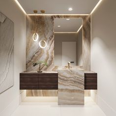 a bathroom with marble counter tops and lights on the wall, along with a plant