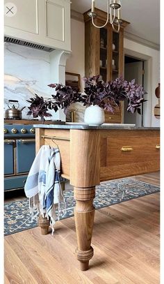 a kitchen island with towels hanging from it's legs and a potted plant on top