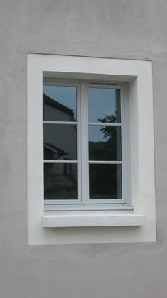 a cat sitting on the ledge of a window