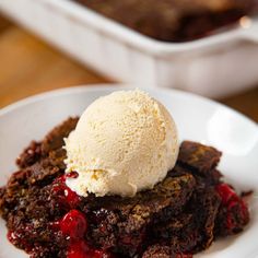 a white plate topped with cake and ice cream next to a pan of chocolate brownies