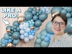 a woman standing in front of balloons with the words like a pro above her head