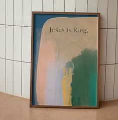 a painting with the words jesus is king on it in front of a tiled wall